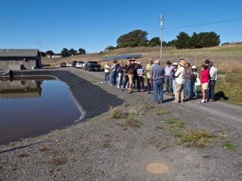 People gathered by a man-made body of water